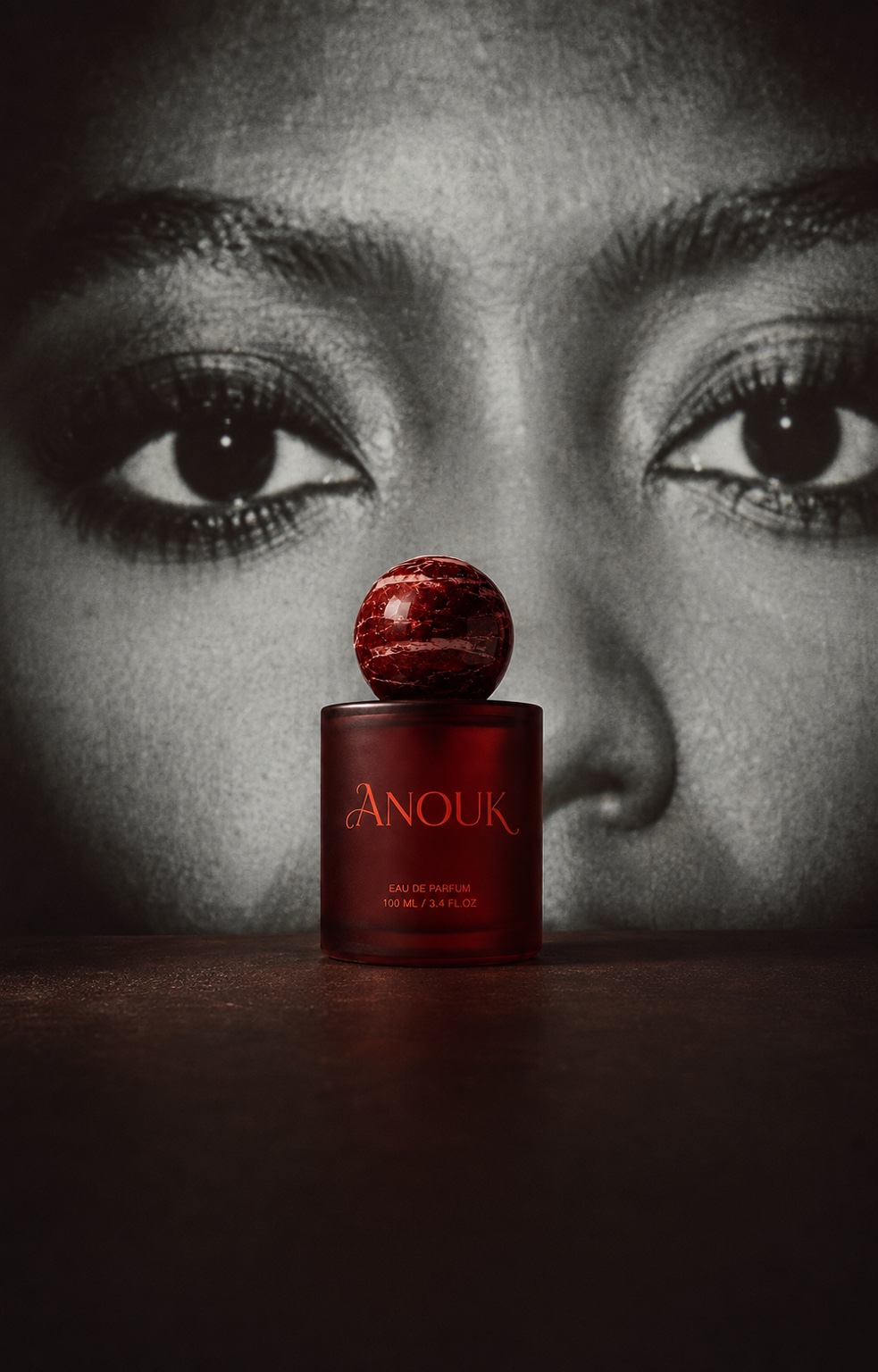 Oxblood Anouk fragrance bottle against a black and white portrait